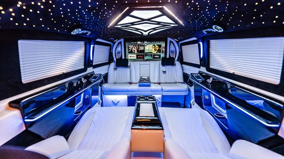 Mavi aydınlatmalı geniş VIP minibüs iç mekânı